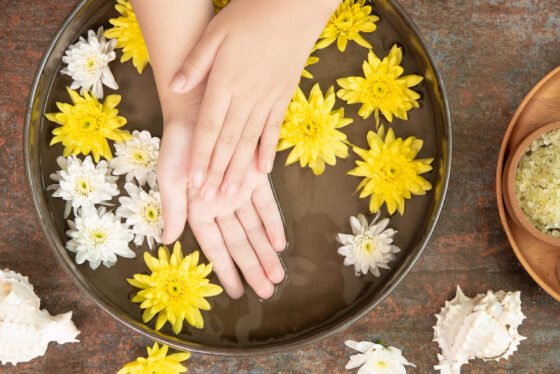 Female hands and bowl of spa water with flowers, close up. Hands Spa.Manicure concept.